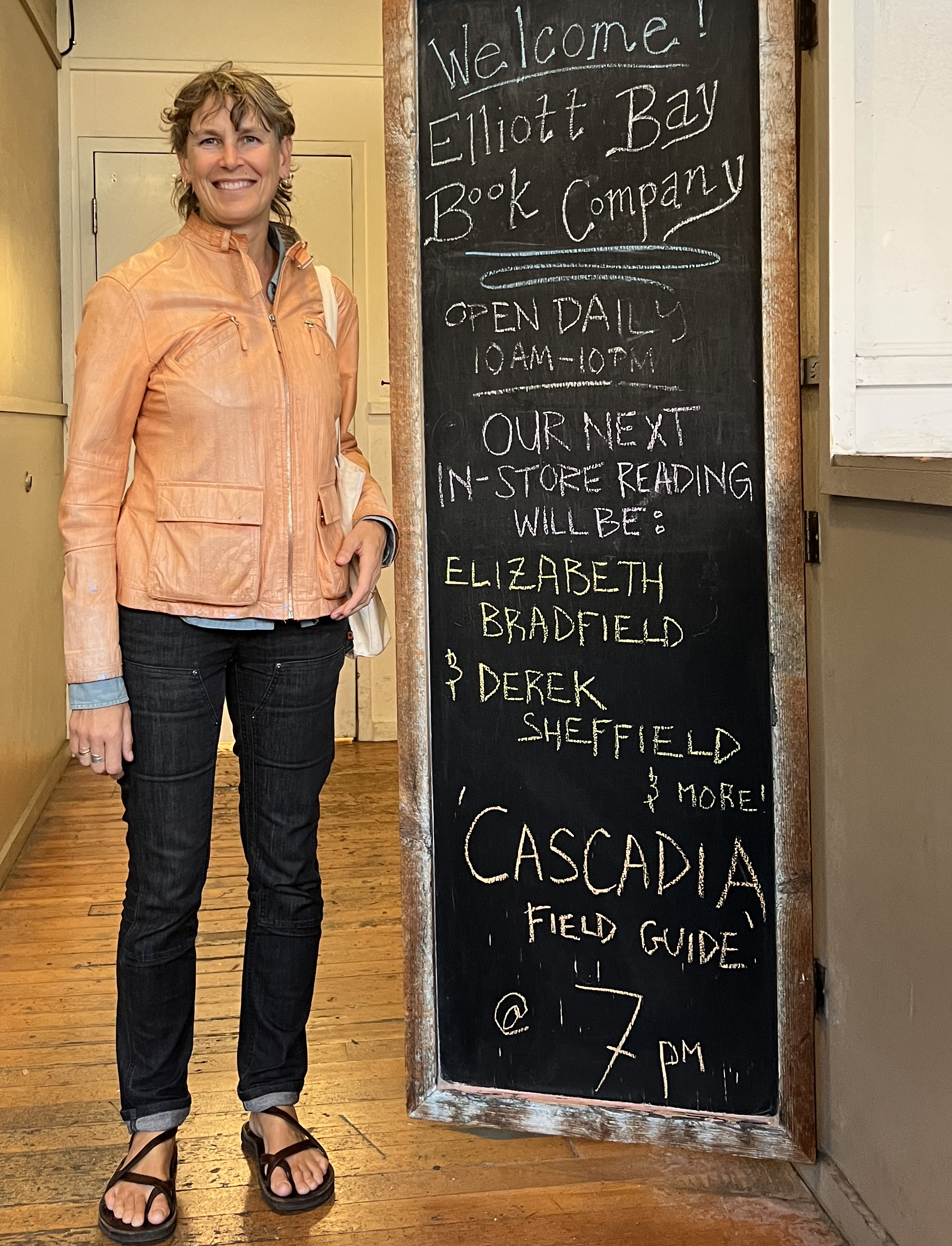 Elizabeth Bradfield standing next to chalkboard sign